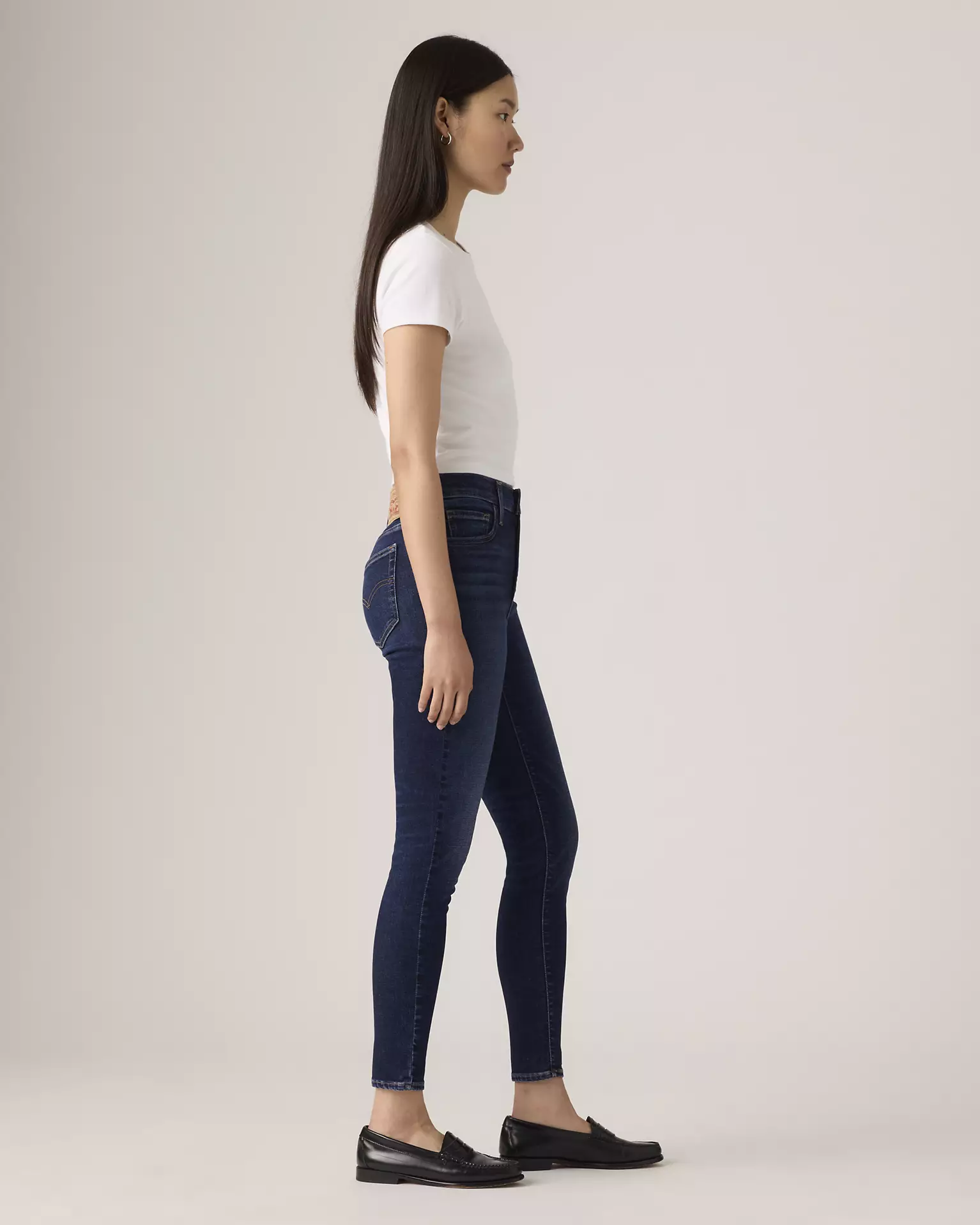 Levi’s 720 High Rise Super Skinny Women’s Jeans side view on model in dark blue denim